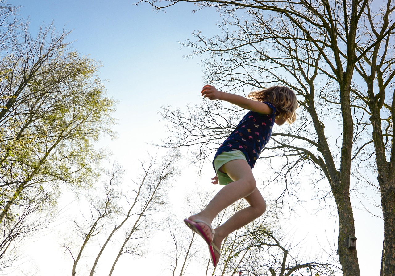 Child jumping on a trampoline in a garden — Pixabay